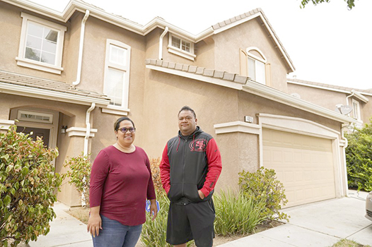 Makerita Iosefo-Va'a and her husband Shaun Va'a pose in front of a relative's home