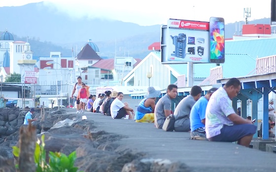 Apia residents sitting on the sea wall