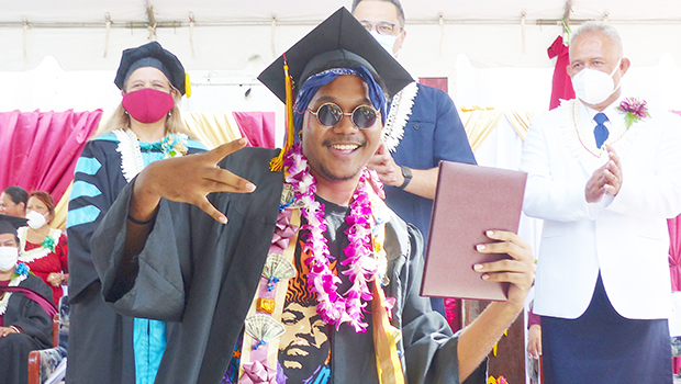 ASCC grad with his diploma, Lt. Gov in the background