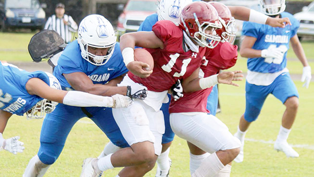 Tafuna Warriors ball carrier trying to escape Samoana’s defenders 