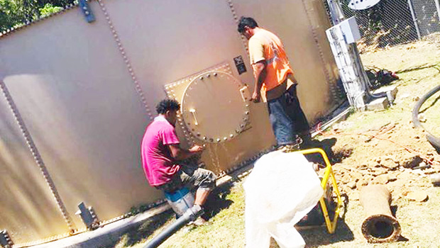 Two ASPA employees working on water tank in Aunu'u.