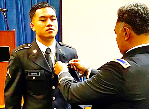 PV2 Nikolao II Chacko Mutini having his wings pinned on by his brother John.