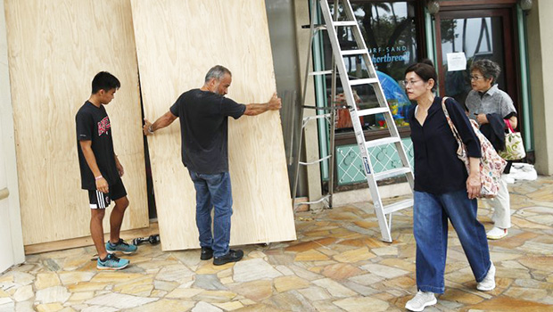 James Fujita, left, and Reid Fujita take down plywood boards