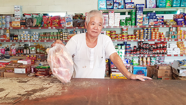 Mr Lin of Peta Lin Store holds bag of chicken