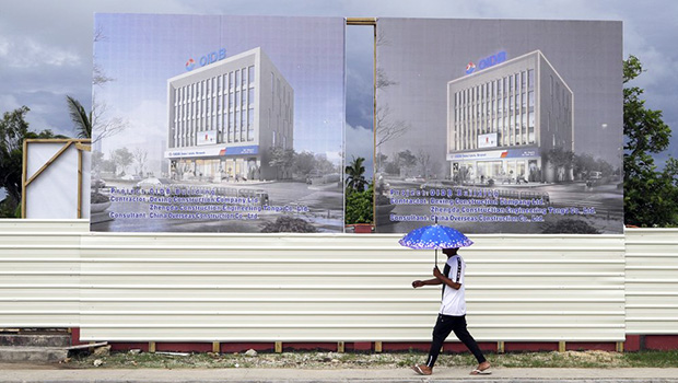 a man walks past a development site for a Chinese Investment bank in Nuku'alofa, Tonga