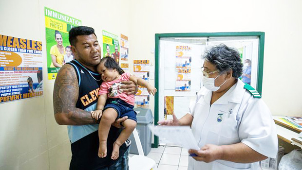 Nurse Fa'atafa Tavita (R) speaking with a father holding his child at the Apia Town Clinic in Samoa's capital city Apia. 