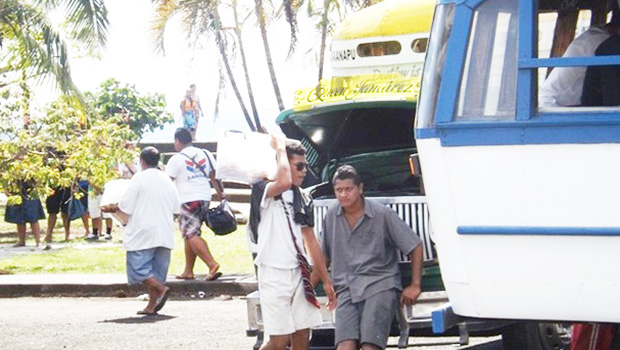 Street vendors in Apia around a bus.