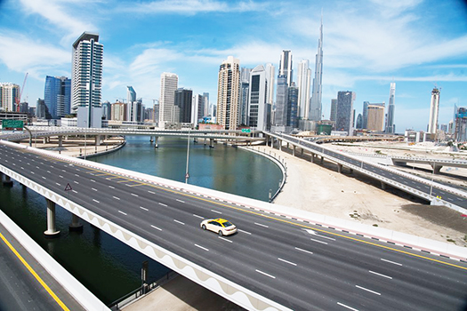 A lone taxi cab drives over a typically gridlocked highway with