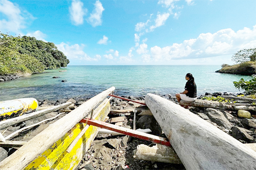 Eseta Vusamu sits near the water