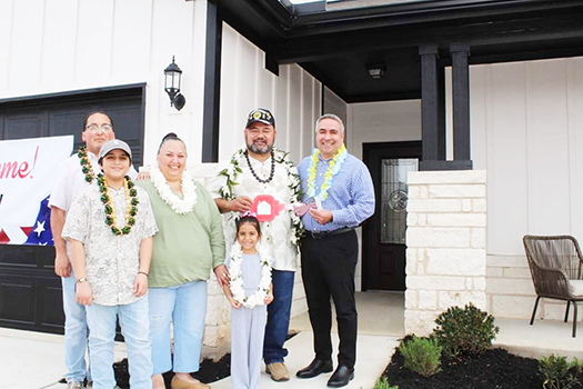 Taetuli and family in front of their new home.