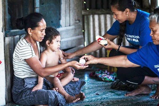 Lead coordinator Susitina Lene helps to administer treatment to a family in Leauvaa