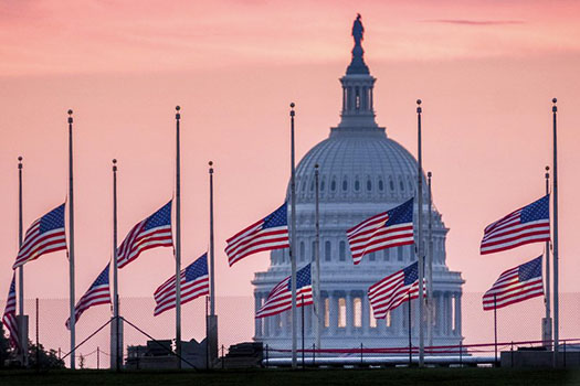 U.S. Capital building with flags at half staff