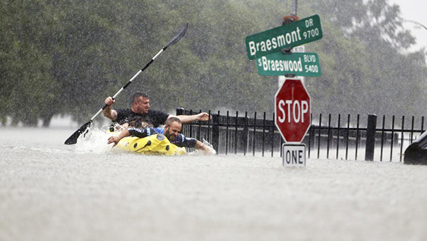 Flooding in Houston with two men paddling in the water