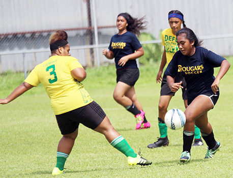 A Cougars player (right) dribbling away from a Leone defender during