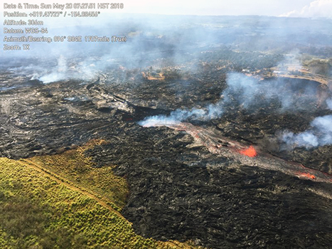 In this Sunday, May 20, 2018, aerial photo provided by the U.S. Geological Survey, lava from the eastern channel of the Fissure 20 complex flows into a crack in the ground in Pahoa, Hawaii. Kilauea volcano began erupting more than two weeks ago and has burned dozens of homes, forced people to flee and shot up plumes of steam from its summit that led officials to distribute face masks to protect against ash particles. (U.S. Geological Survey via AP) 