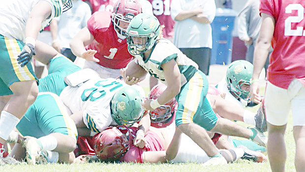 Leone Lions running back Wylan Faga avoids a pile-up and continues to run