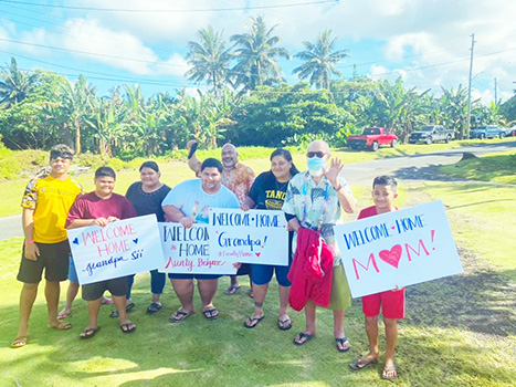 Families with signs welcoming their loved ones home