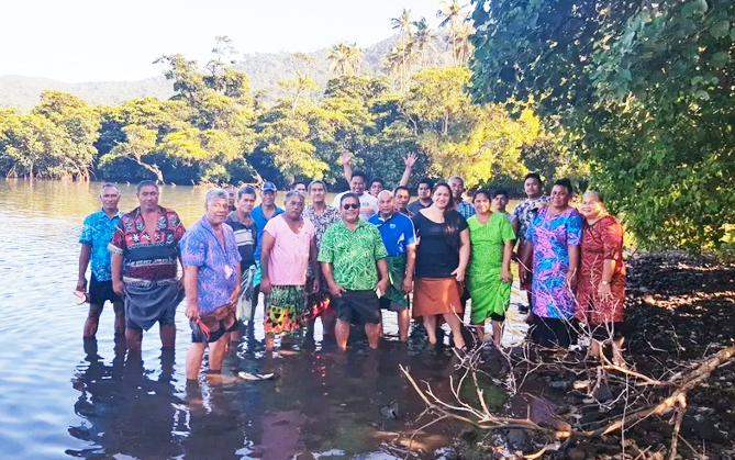 Village leaders at low tide among mangroves