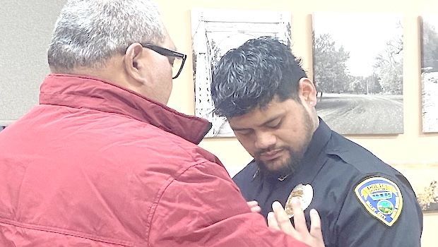 Georgia Mageo receiving his badge from his father.