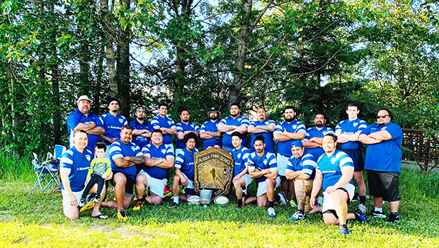 the Manu Bears rugby team, shows team officials and players posing for a photo