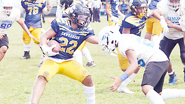 Marist Crusaders running back Kanai Satele trying to avoid a tackle from a Samoana Shark defender 