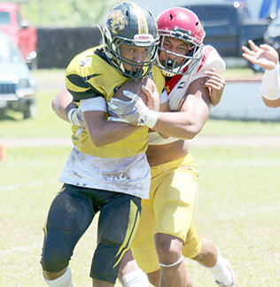 Tafuna Warriors Francisco Mauigoa and a Nuuuli Wildcat ball carrier