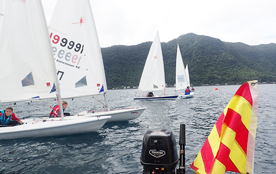 Laser sailors sitting at the ready waiting for the start flag to drop