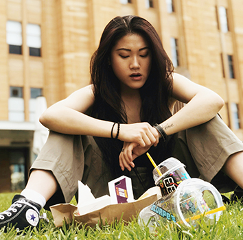 Young woman with empty junk food packages