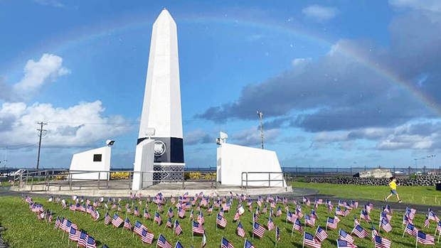 Small American Flags in front of Veterans Memorial Monument with rainbow overhead