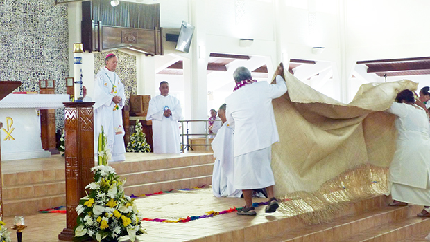 Bishop-elect Kolio Tumanuwao Etuale (kneeling as he is covered by a fine mat)