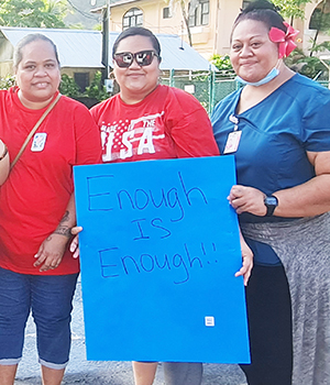 Three nurses with sign