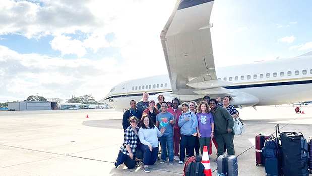 NuWest traveling healthcare workers posing by airplane in American Samoa