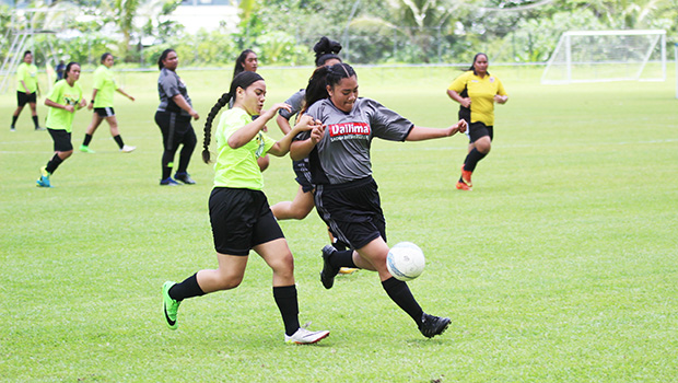 A Pago Youth player challenges a Taputimu Youth defender