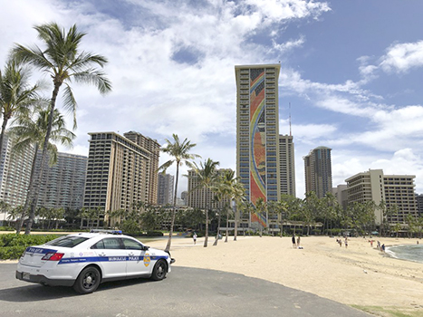  a police officer arrives to tell people to leave Waikiki Beach