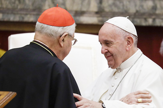 Pope Francis exchanges greetings with Cardinal Angelo Sodano, left