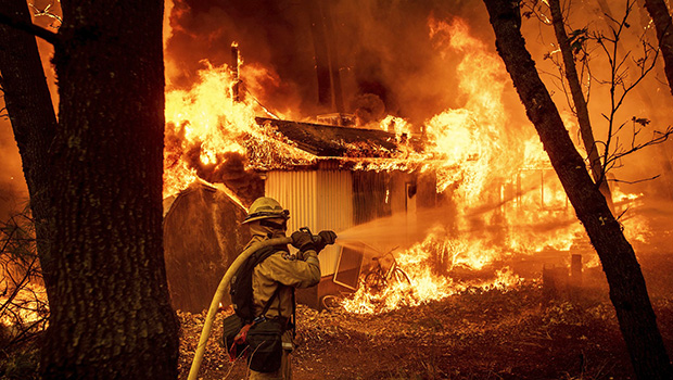 Flames consume a home in Magalia, California, Friday.