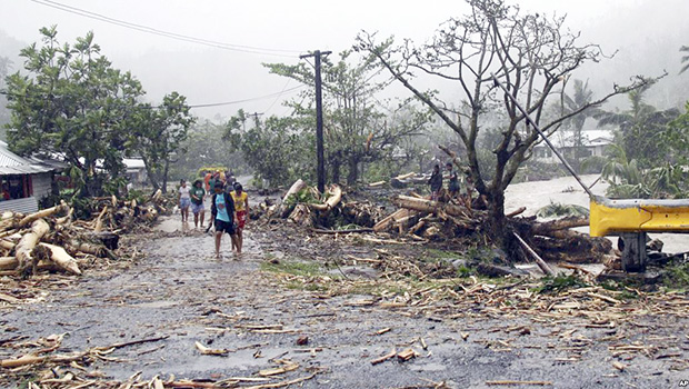 People walk through debris in Samoa's capital Apia, Dec. 14, 2012, after cyclone Evan