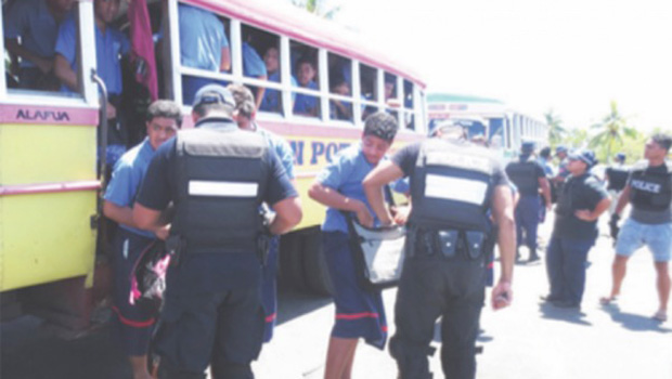 Police talking to students near school bus.