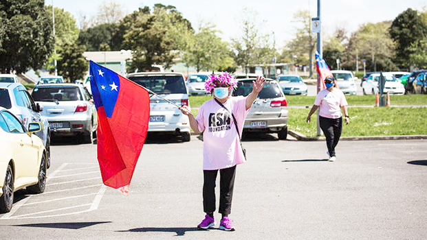 Woman with mask waving Samoan flag