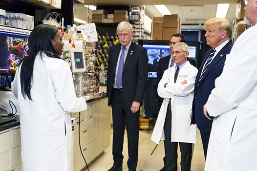 Dr. Kizzmekia Corbett, left, senior research fellow and scientific lead for coronavirus vaccines and immunopathogenesis team in the Viral Pathogenesis Laboratory, talks with President Donald Trump 