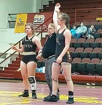 Stephanie Floor with her arm upraised after wrestling victory