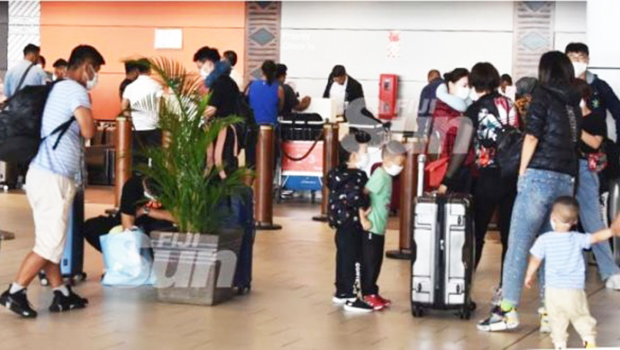 Travelers wearing face masks arrive at airport