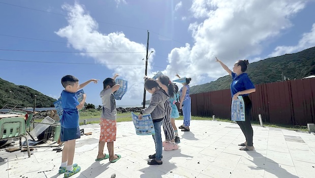 Students and teacher looking at clouds in the sky