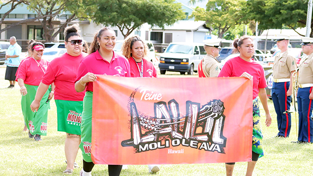 Teine Laulii Hawaii members marching with banner
