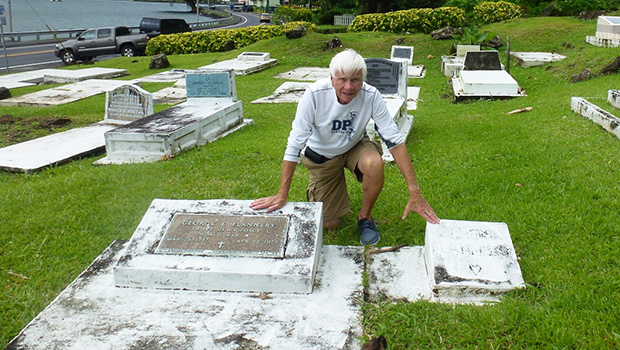 Tom Blake touches the two gravestones in Pago Pago, of his friend Mark Flannery’s parents