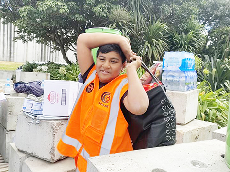 Young man with cases of donated water