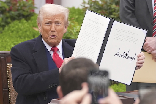 President Donald Trump holds a signed executive order