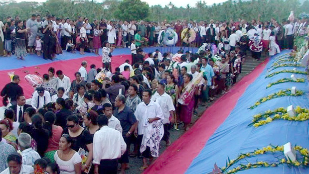 Family members laying flowers and wreaths to farewell the victims at the Tafaigata Cemetery before the mas graves were covered with cement.