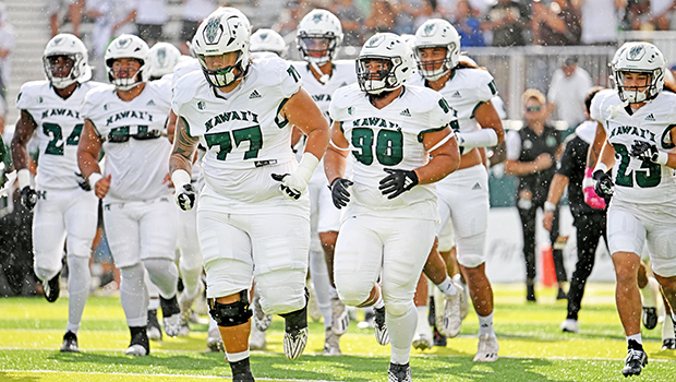 John Tuitupou with other UH Rainbow Warriors taking the field