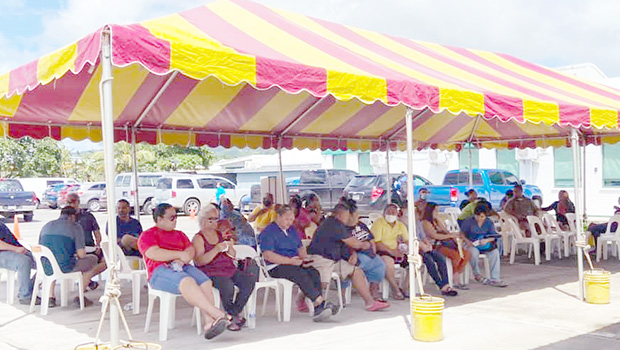 Individuals waiting to get their COVID-19 vaccine under a tent next to the DoH quarantine facility in Tafuna
